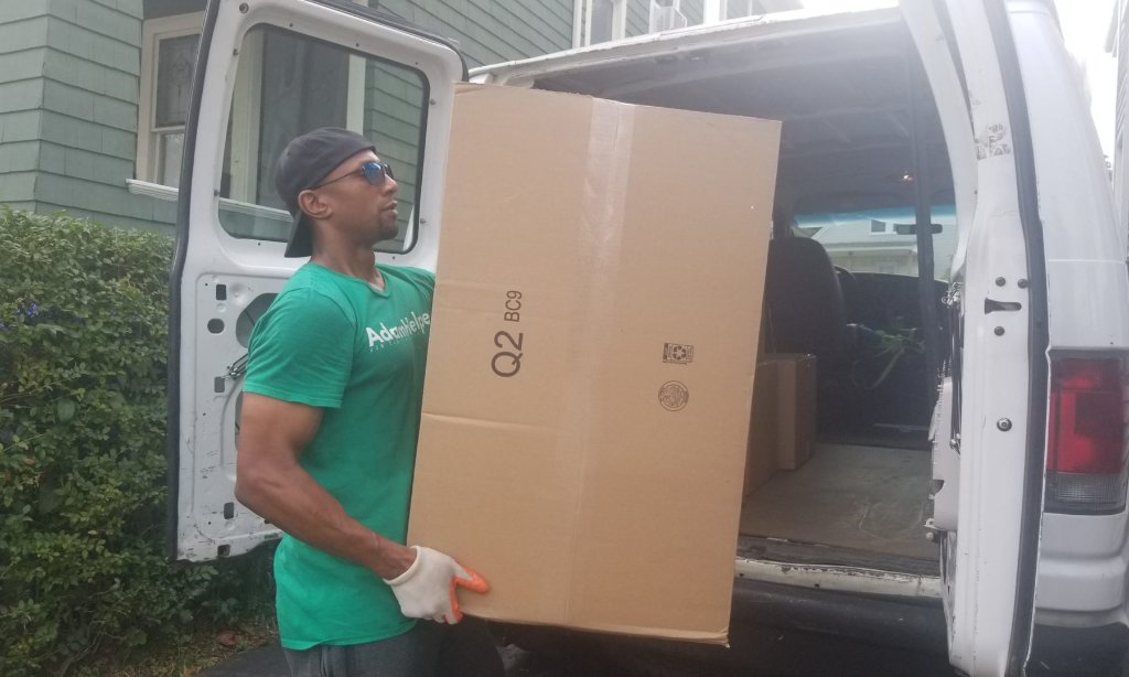 Adam Spencer of AdamHelper loading a box into a moving van.