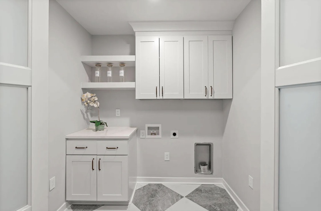 Laundry room with white cabinets and marble tile floor