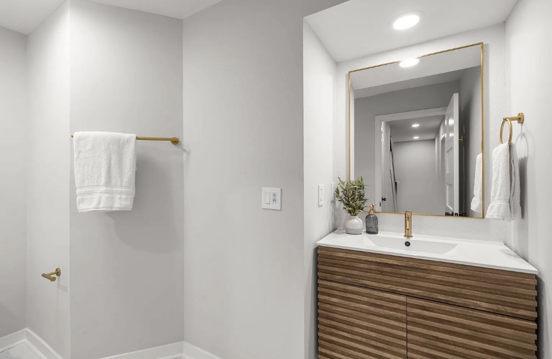 Bathroom vanity with ribbed wood drawers and gold fixtures