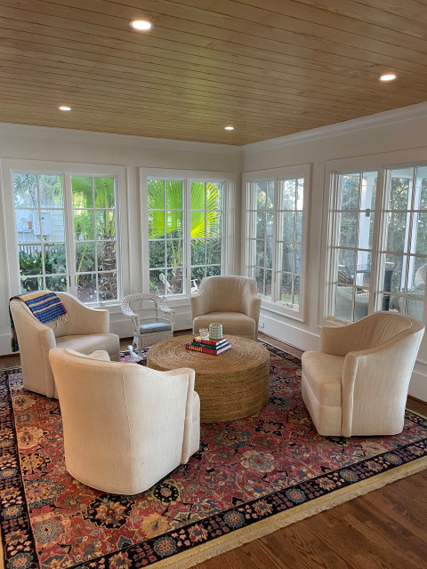 Sunroom with wood-planked ceiling and cream club chairs