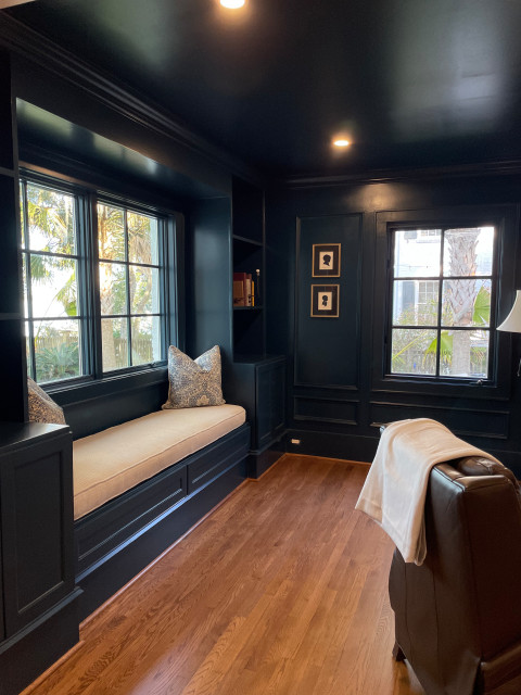 Dark-painted study with built-in window bench and leather chair