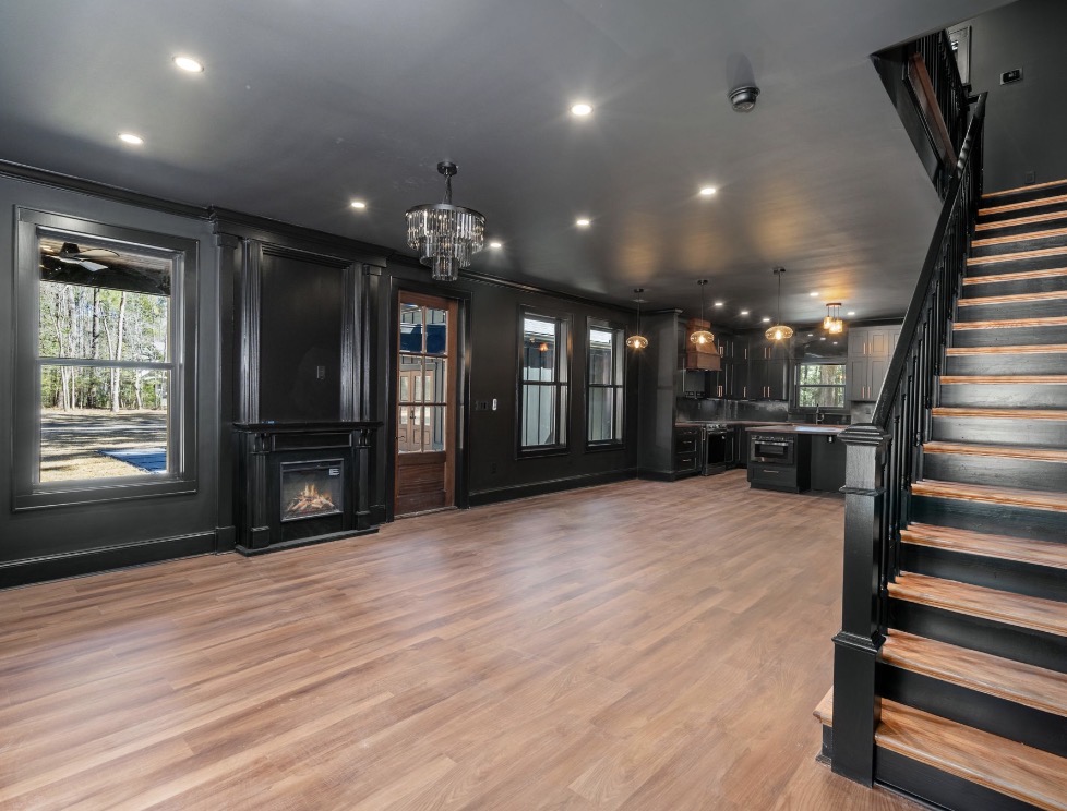 Open living and kitchen space with black staircase