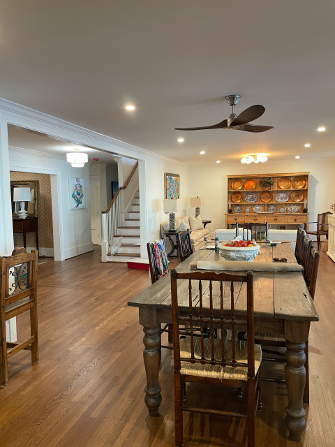 Dining room with farm table and hutch beside the staircase