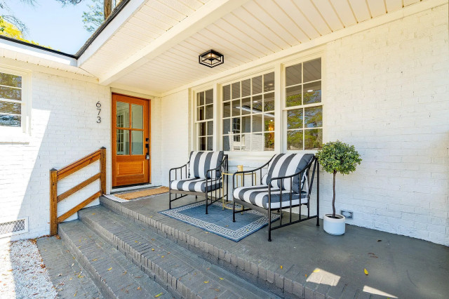 Covered front porch with black metal seating