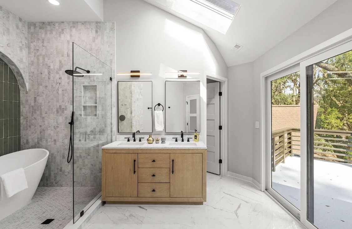 Primary bathroom with skylights, double vanity, and soaking tub