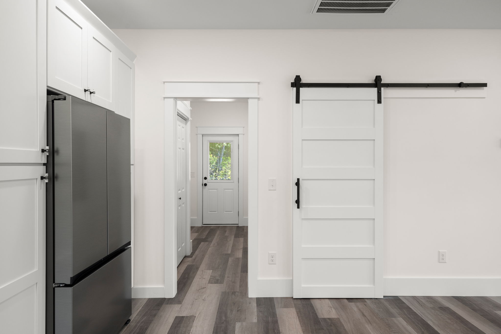 Hallway passage with refrigerator alcove and sliding barn door