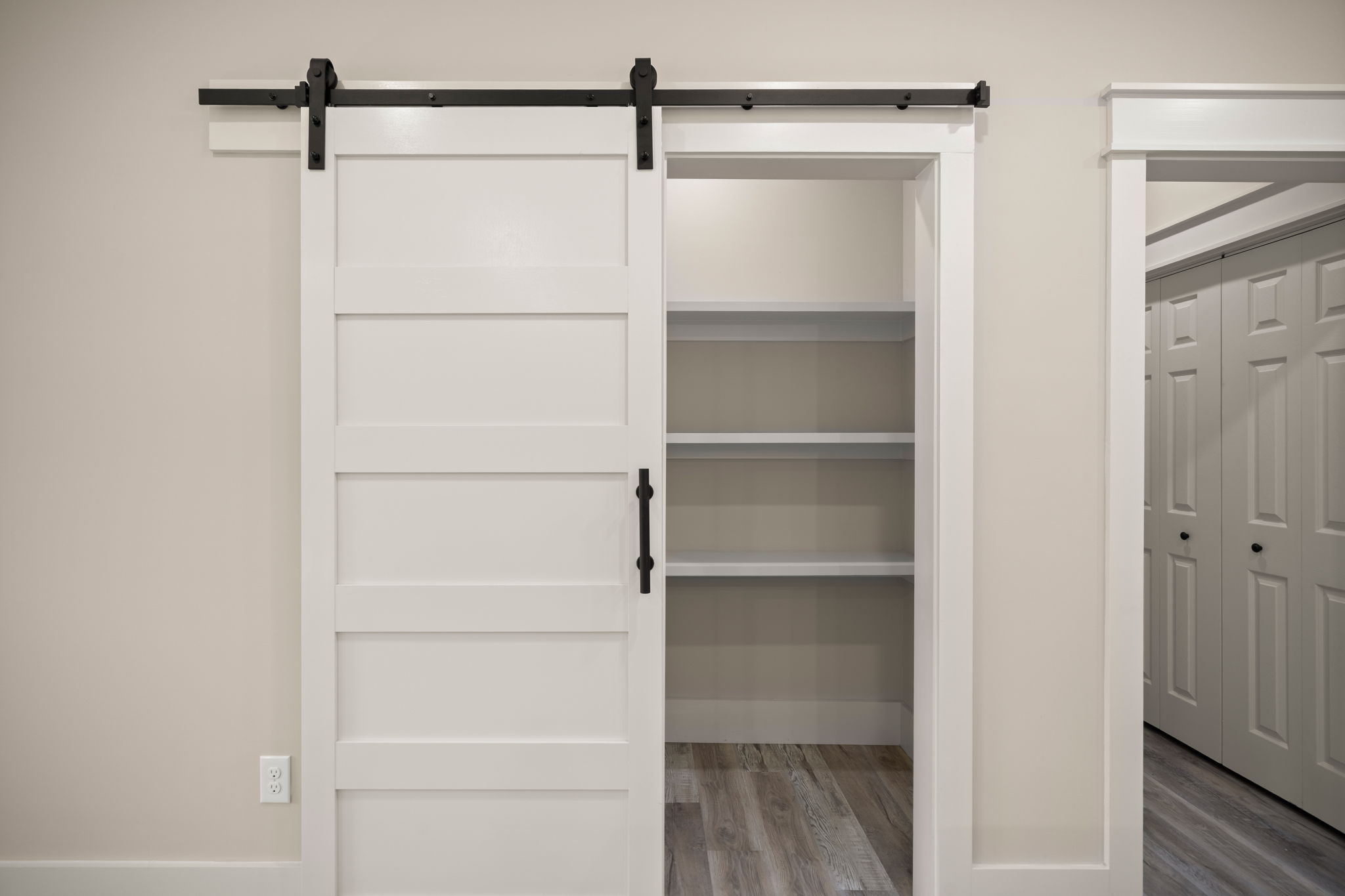 White barn door on black rail covering the closet entry