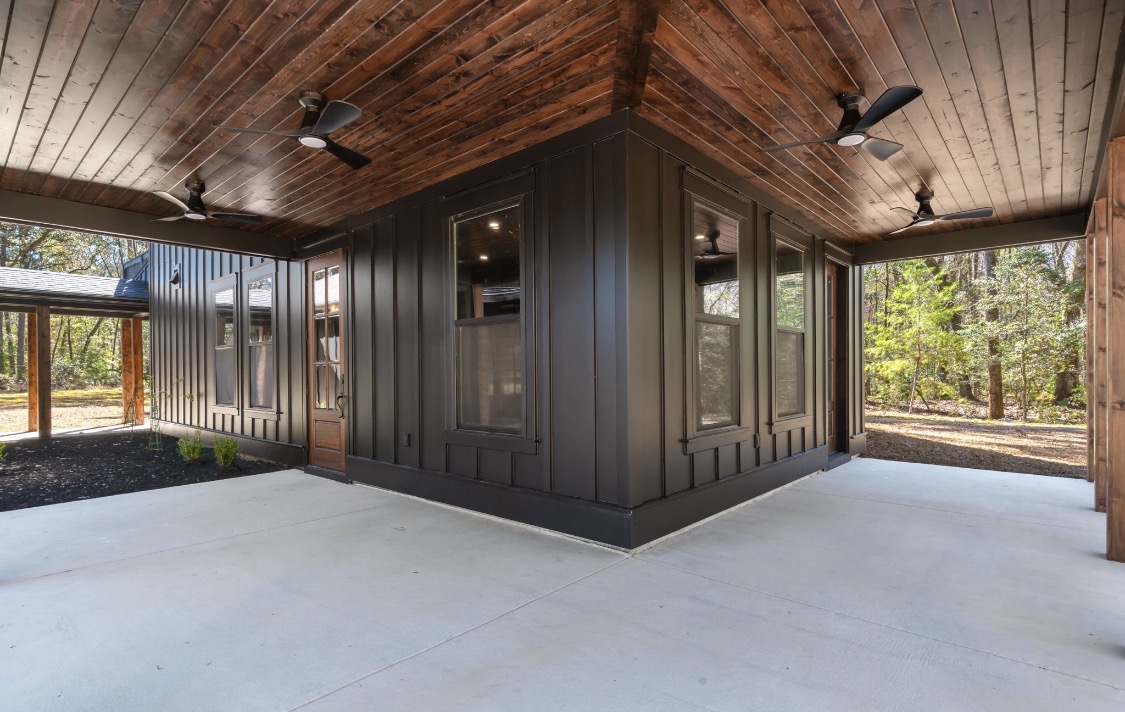 Vaulted wood porch ceiling with black ceiling fans