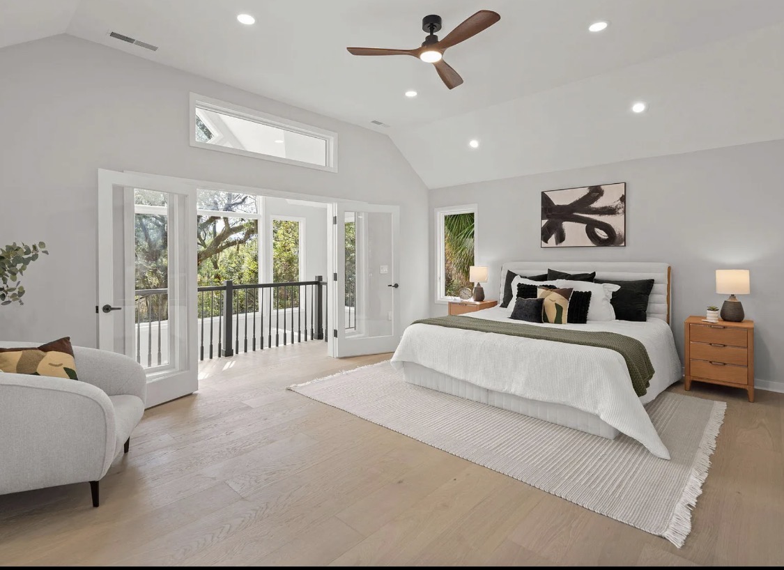 Primary bedroom with balcony doors and channel-tufted headboard