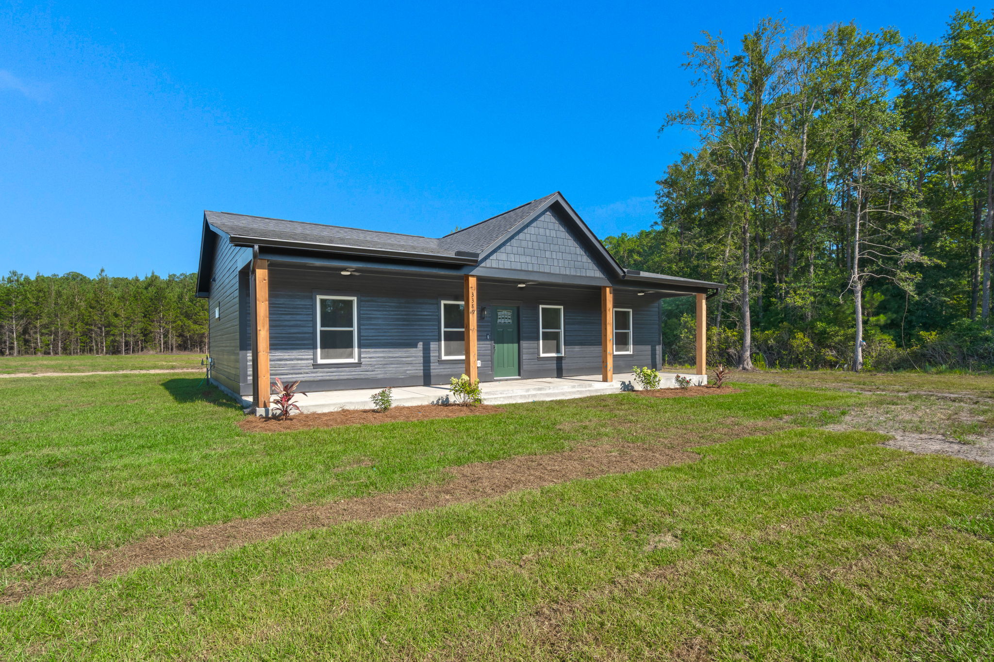 Dark-sided farmhouse with full-length porch and natural wood columns