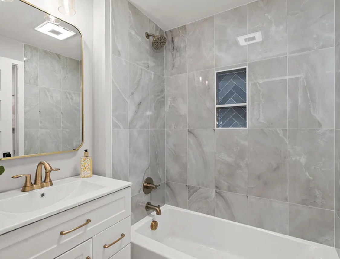 Bathroom with tub-shower combo and brass fixtures