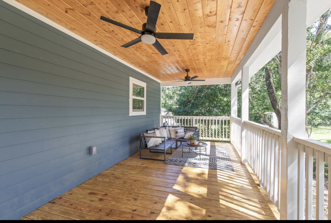 Covered back porch seating area with wood ceiling