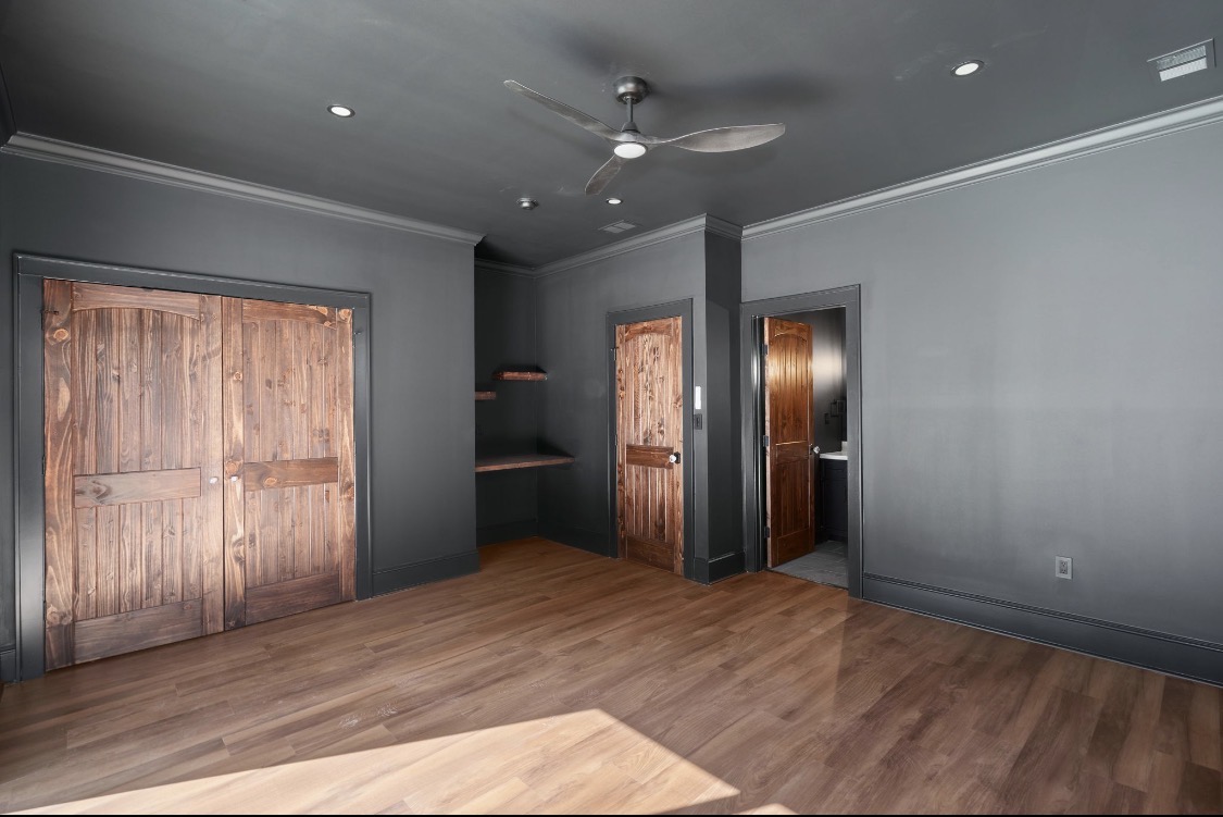 Dark grey room with arched wood doors and built-in shelving