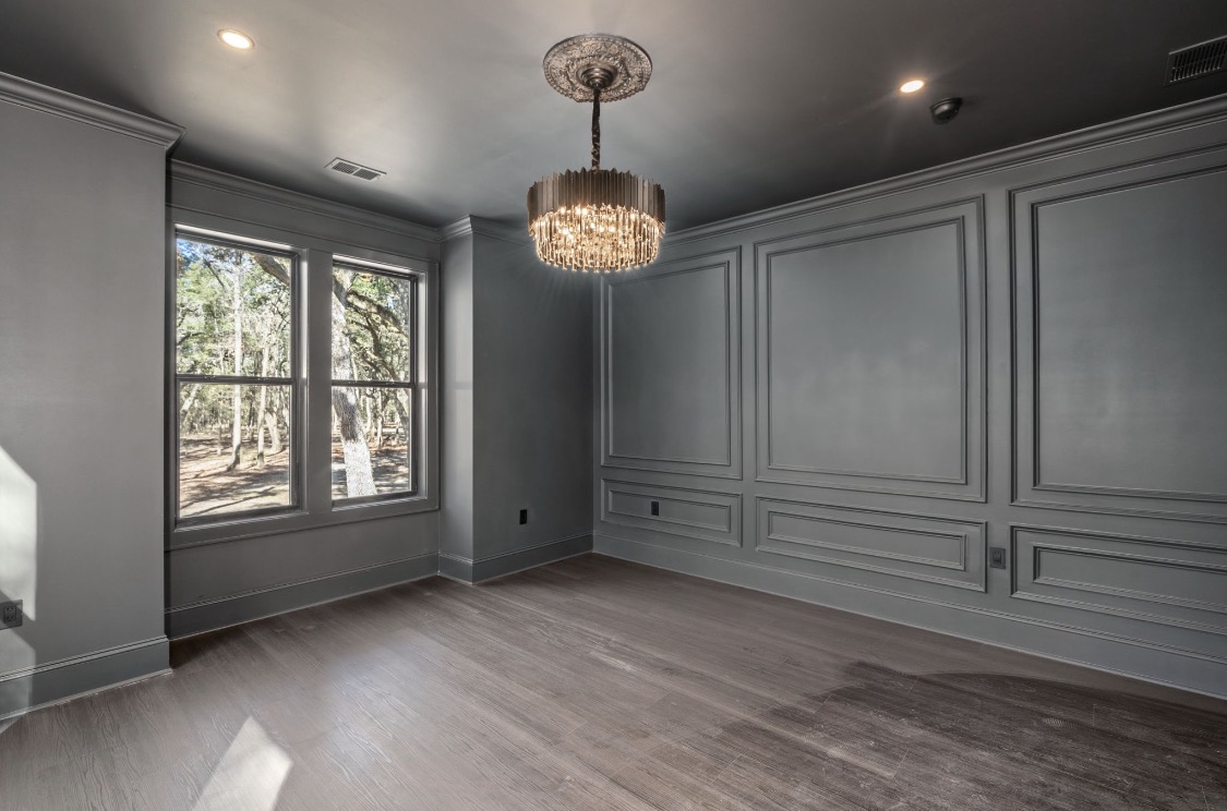 Charcoal paneled room with crystal chandelier and medallion