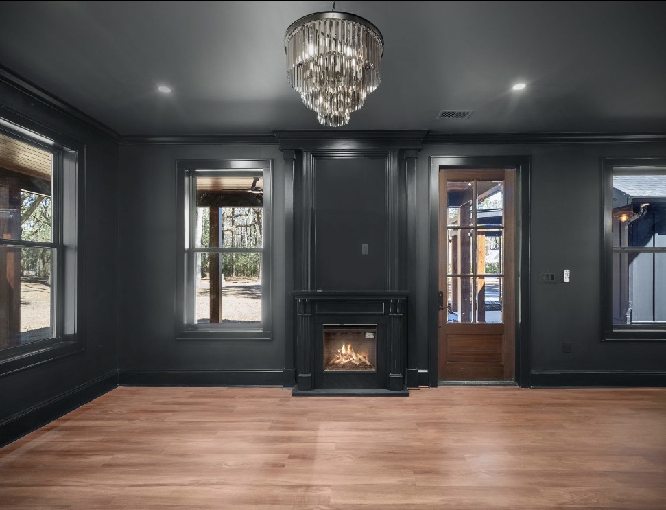 Centered fireplace flanked by windows and wood door