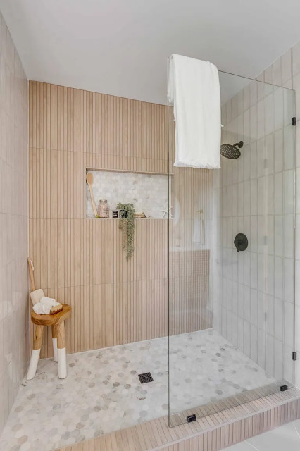 Walk-in shower with oak slat tile and frameless glass door