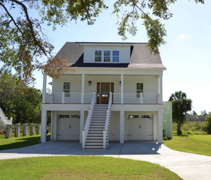 White elevated home with central staircase and gabled dormer