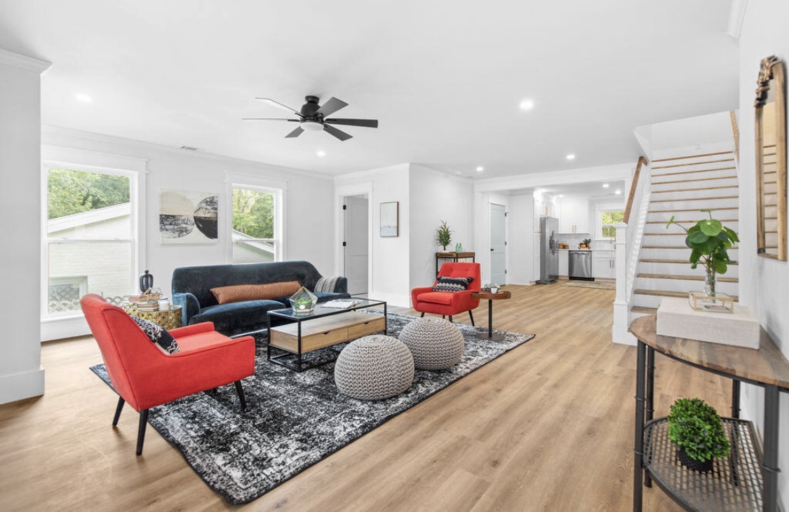 Open living room with navy sofa and red accent chairs