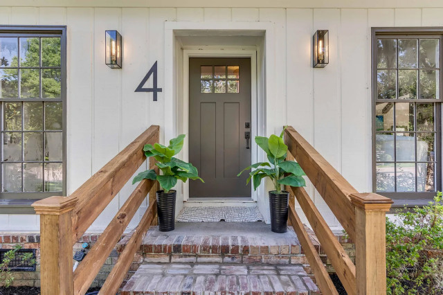 Front entry with brick steps, Edison sconces, and black planters