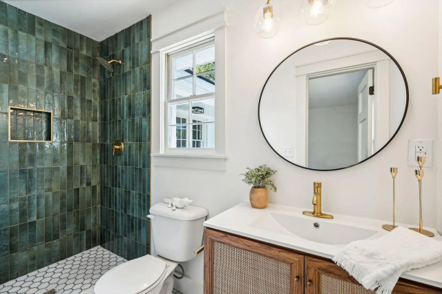 Guest bath with forest green tile and rattan vanity