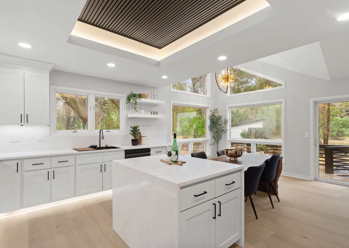 Vaulted kitchen and dining space with wooded views