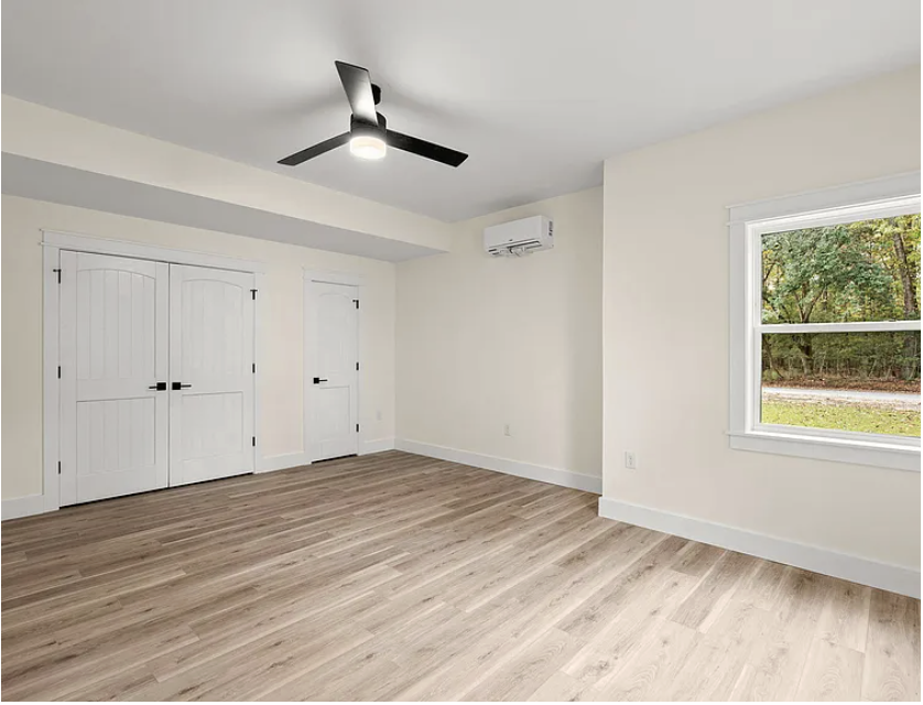 Bedroom with double doors and black ceiling fan