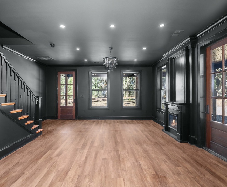 Black-walled living area with crystal chandelier and fireplace
