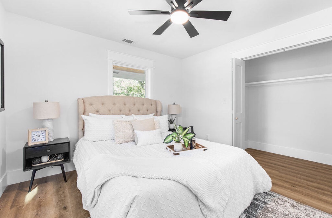Guest bedroom with tufted headboard and black nightstand