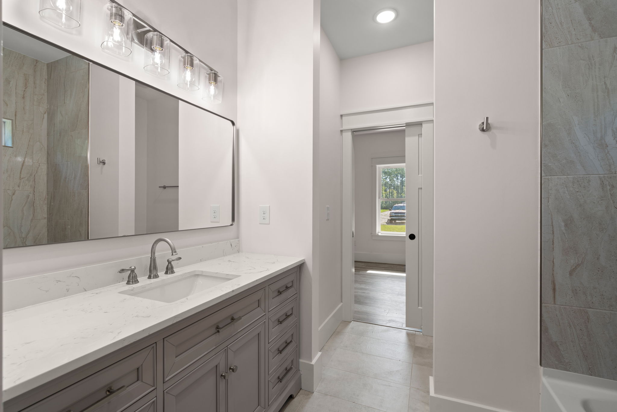 Double vanity with gray wood cabinets and brushed nickel fixtures