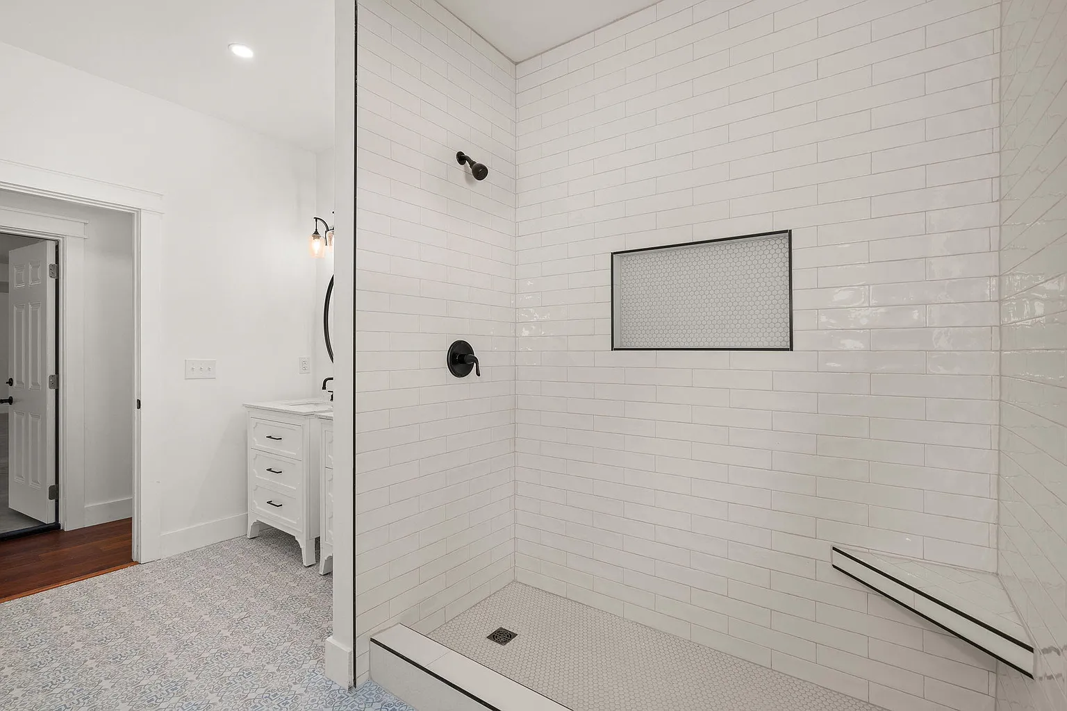 Walk-in shower with subway tile and recessed niche