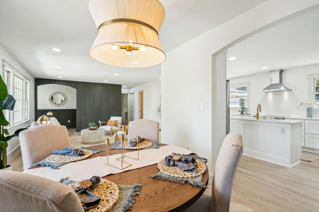 Round dining table with drum pendant opening to kitchen