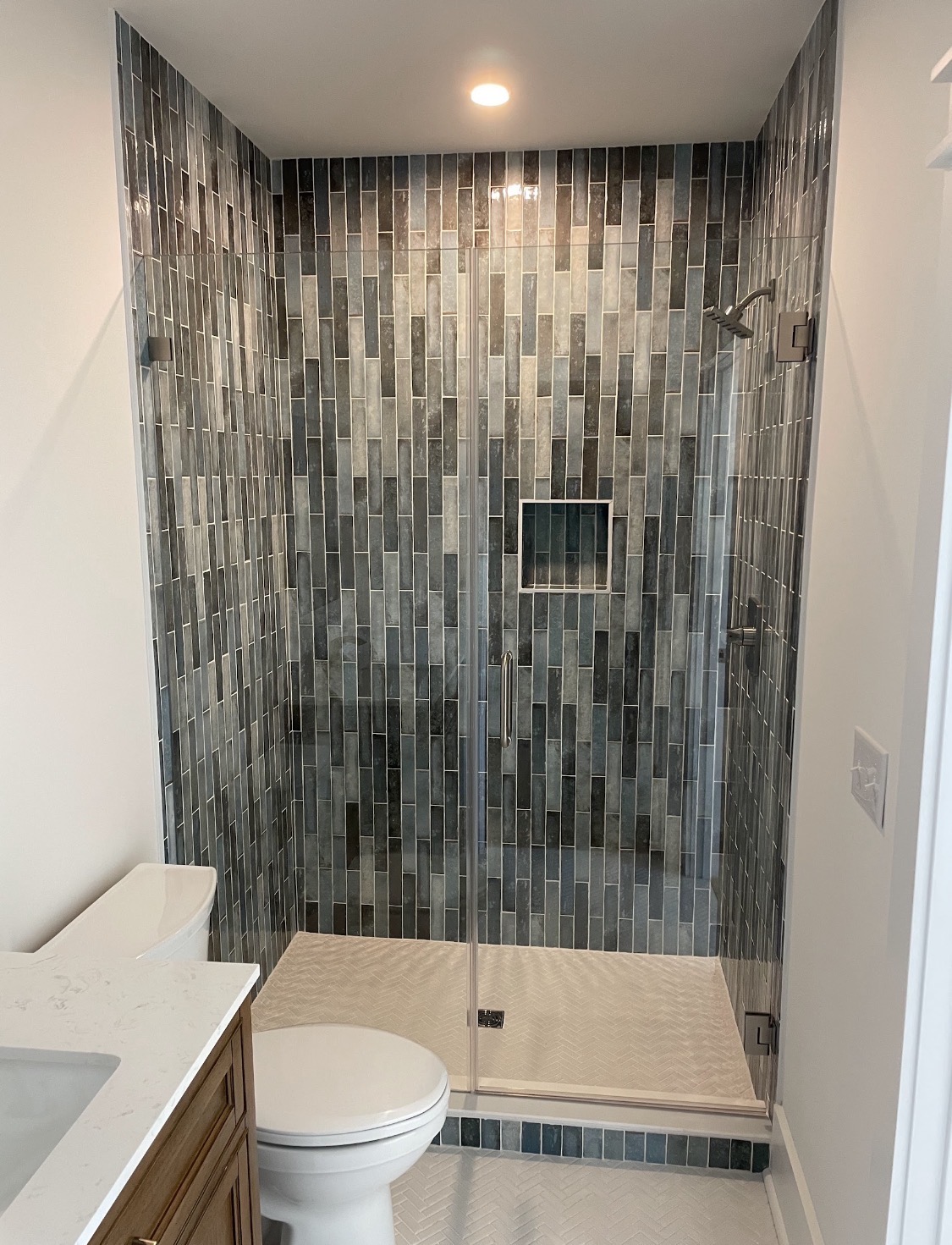 Walk-in shower with herringbone tile floor