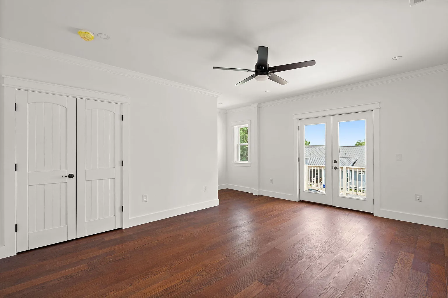 Bedroom with arched double doors and balcony access