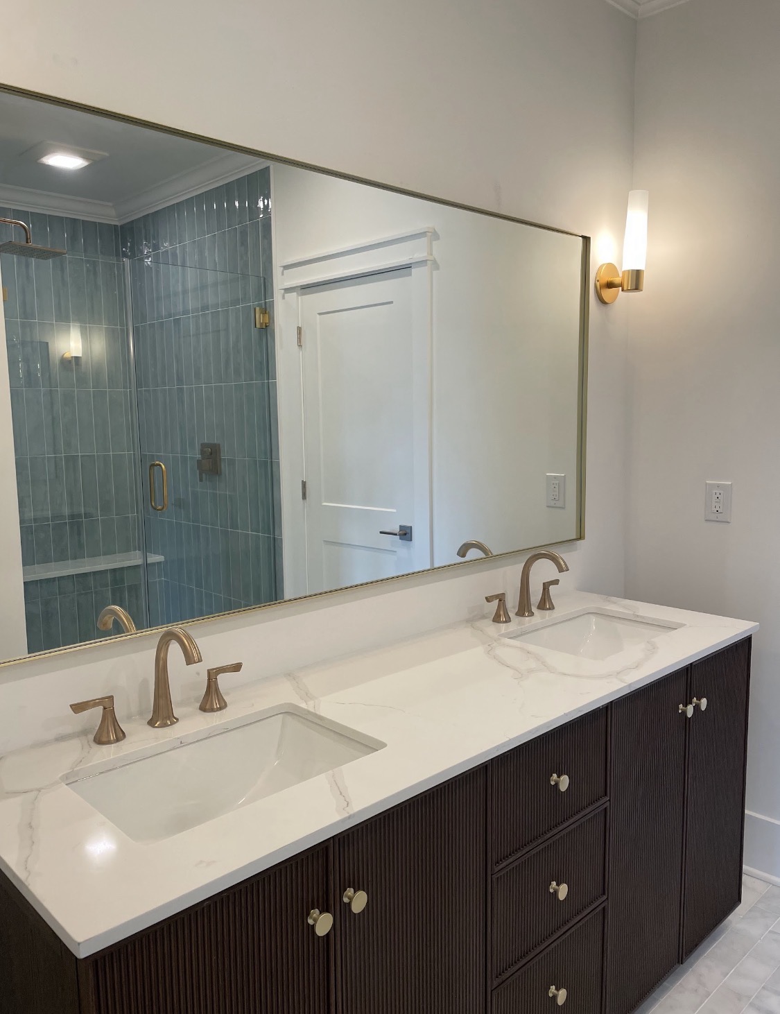 Dual-vanity bathroom with brushed-gold fixtures