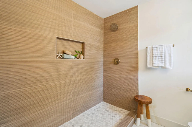 Primary bath walk-in shower with wood-look tile and penny floor