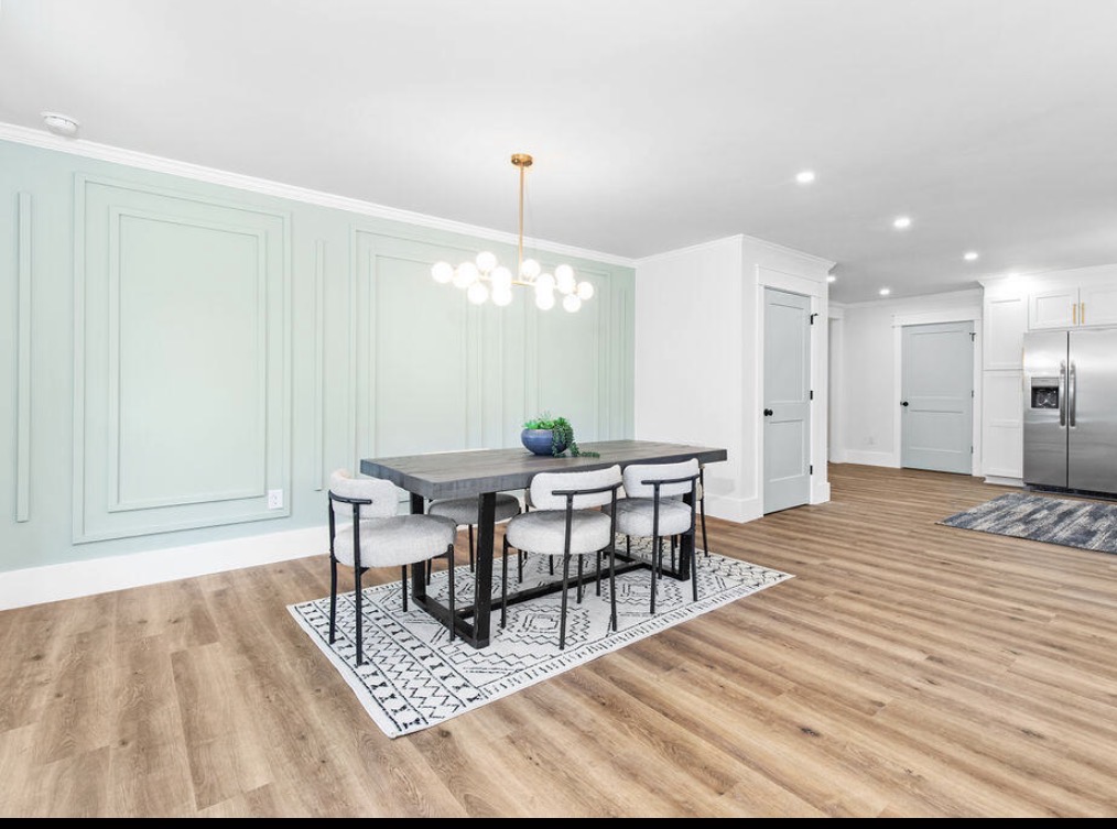 Dining room with sage accent wall and sputnik chandelier