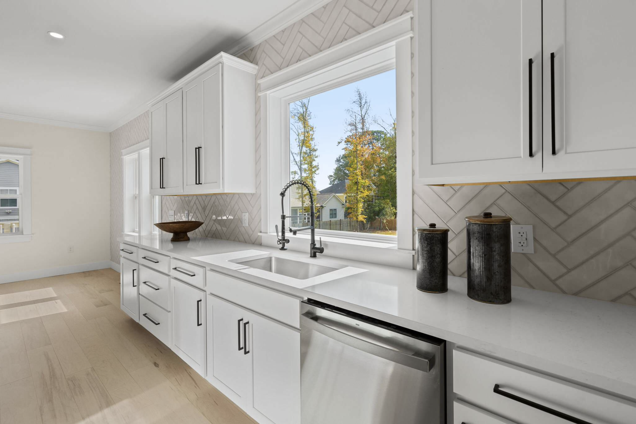 Kitchen sink station with herringbone tile and window