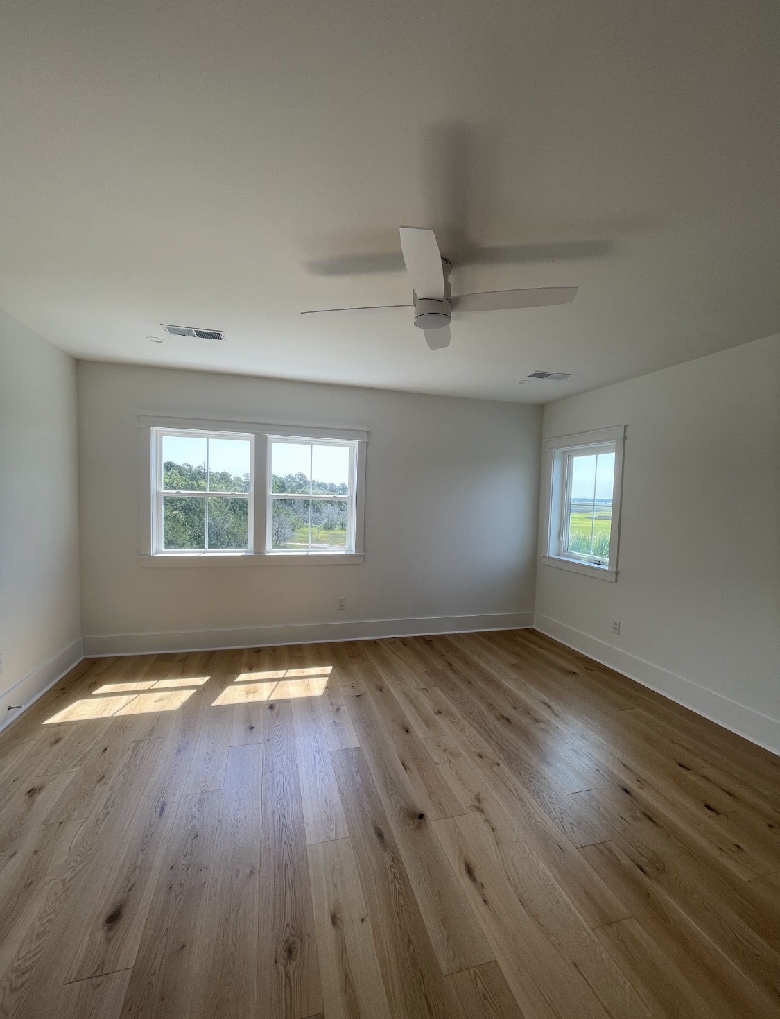 Finished room with light oak floors and marsh views