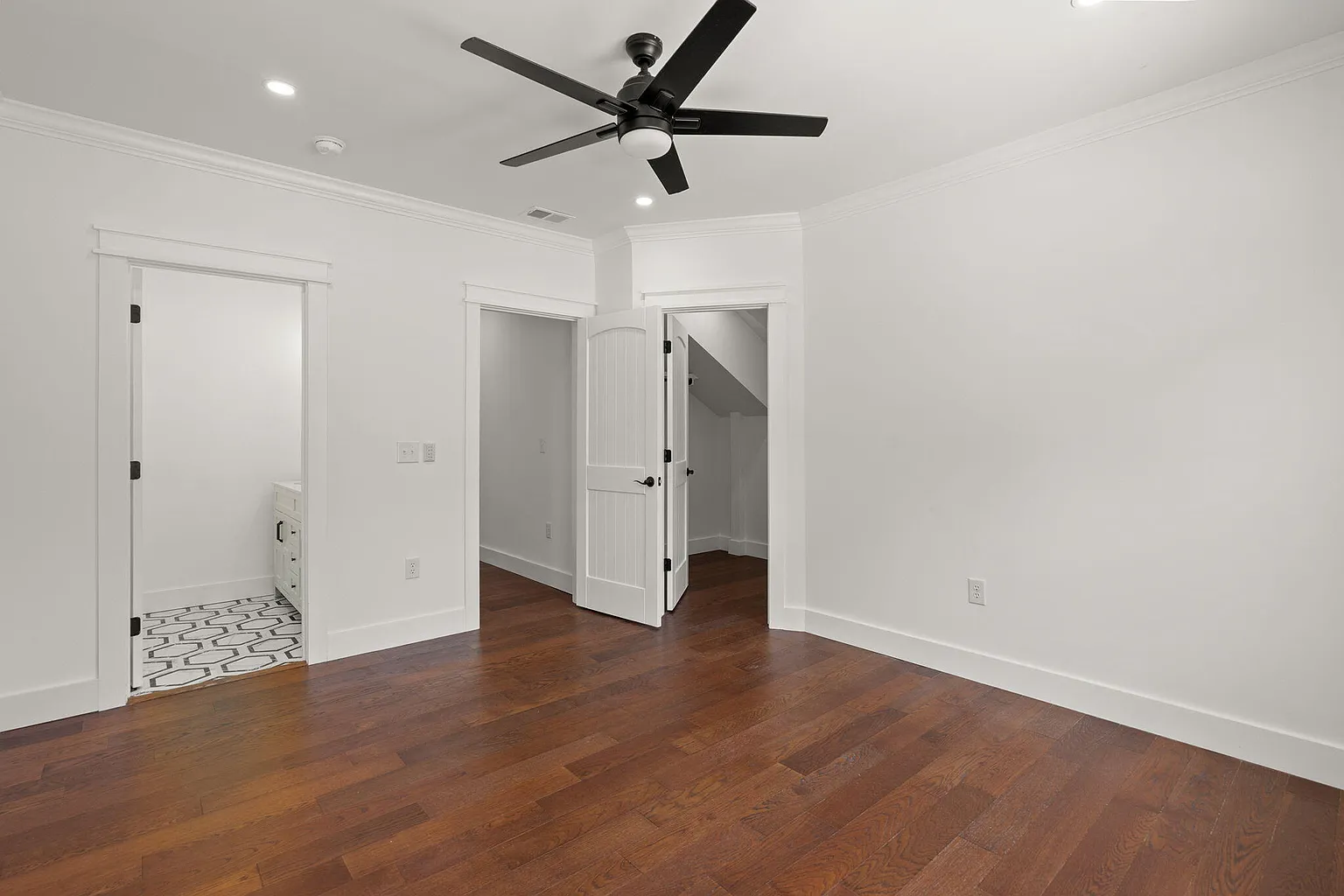 Bedroom with ensuite bath and walk-in closet doorways