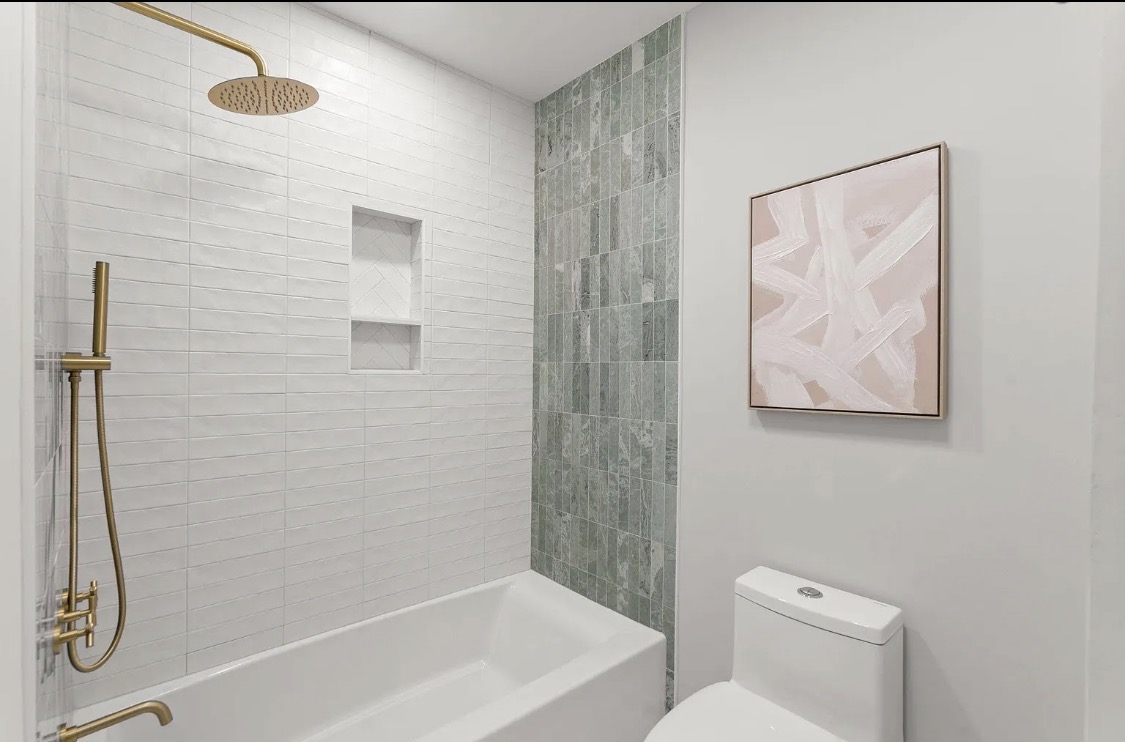 Bathroom with tub, subway tile, and brushed-gold fixtures