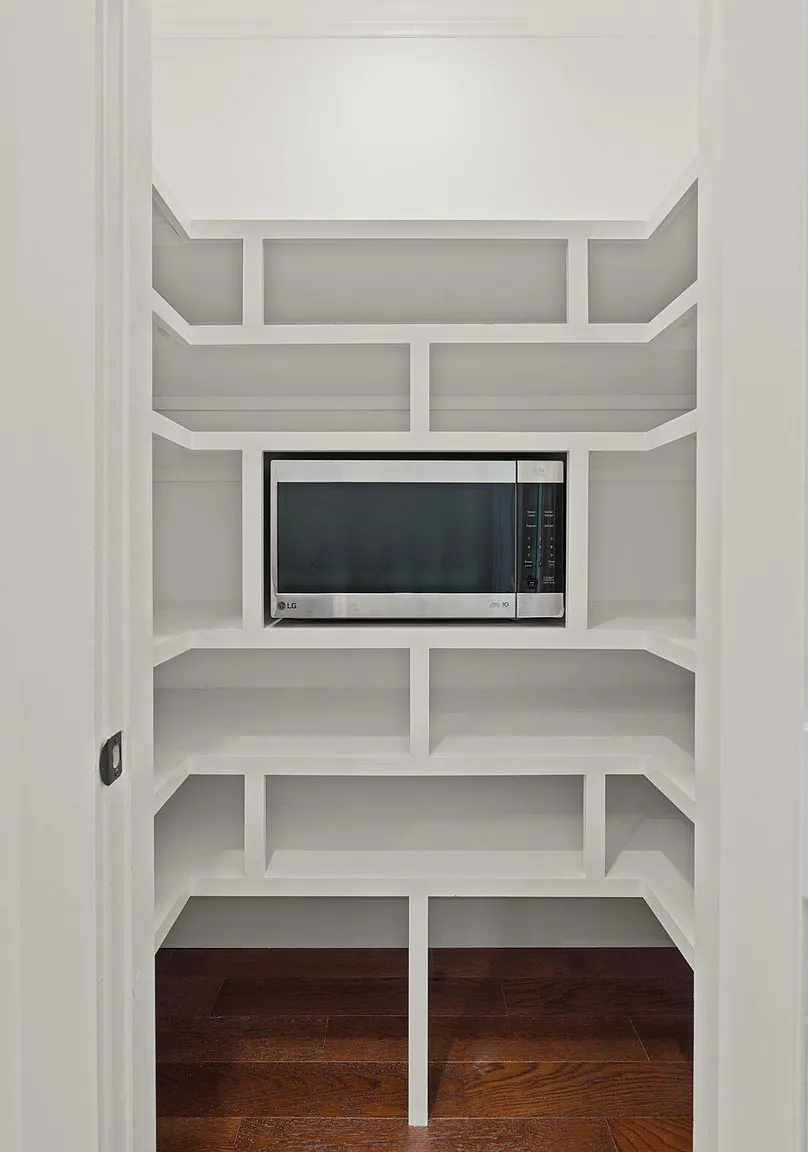 Custom white walk-in pantry with built-in shelving