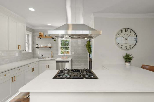 Kitchen island cooktop with range hood and open shelving