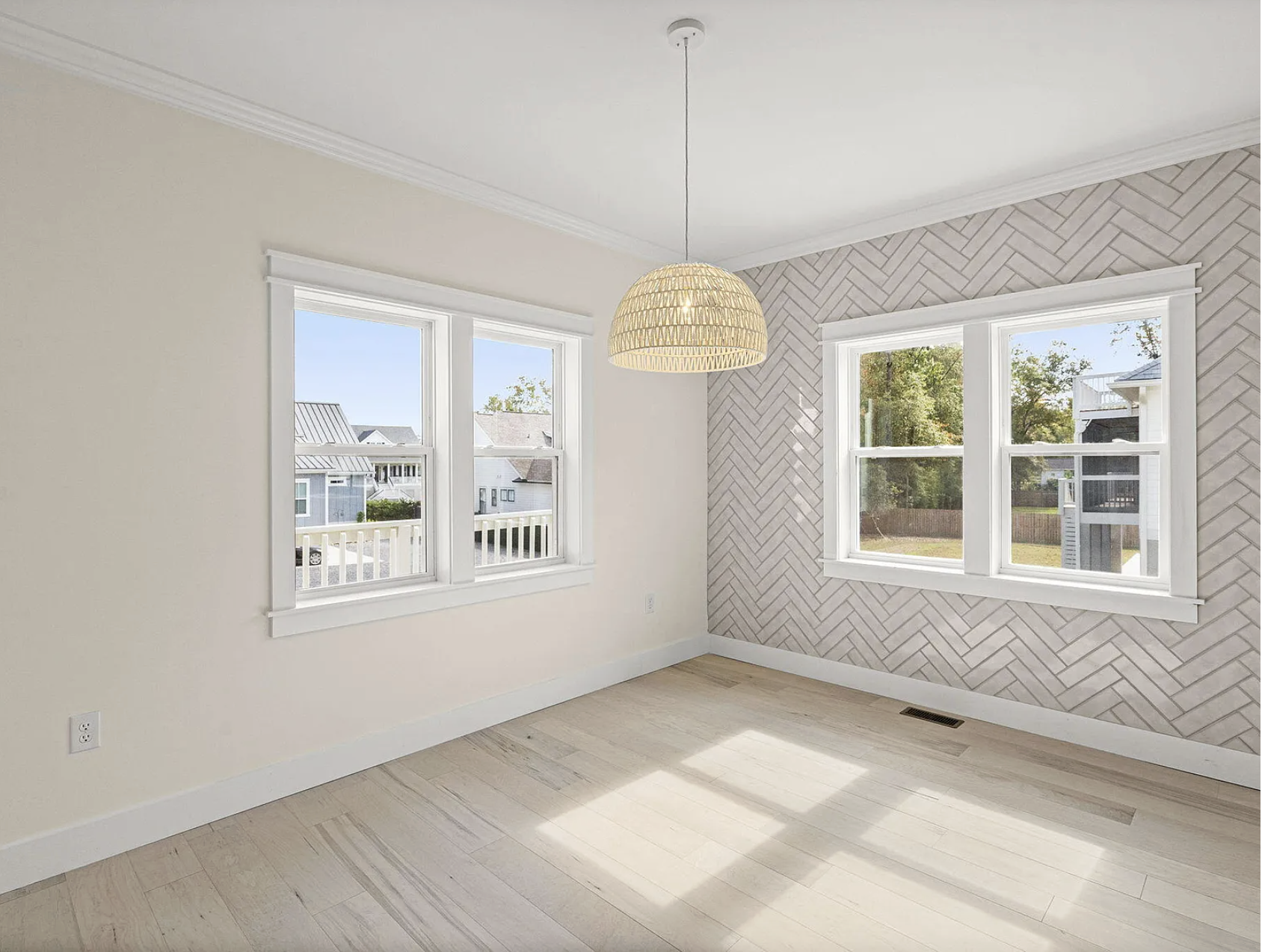 Bedroom with herringbone tile accent wall and wicker pendant