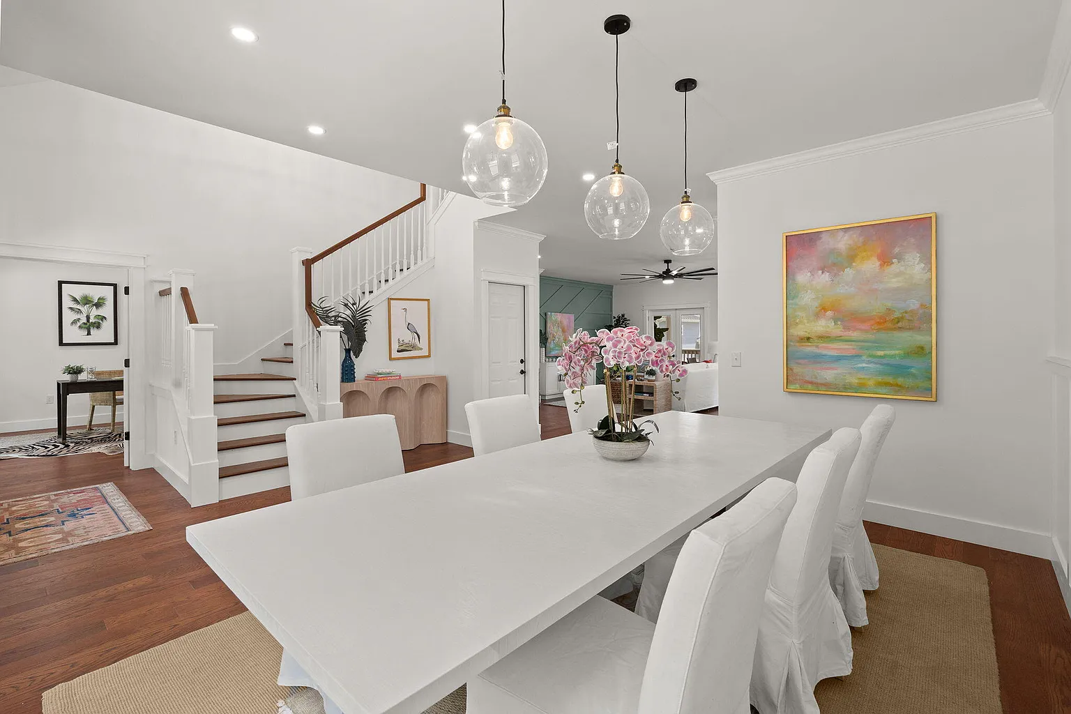 Dining area with orchid centerpiece and staircase beyond