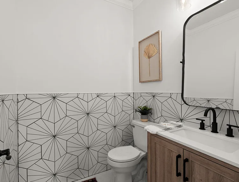 Powder room with patterned tile and wood vanity