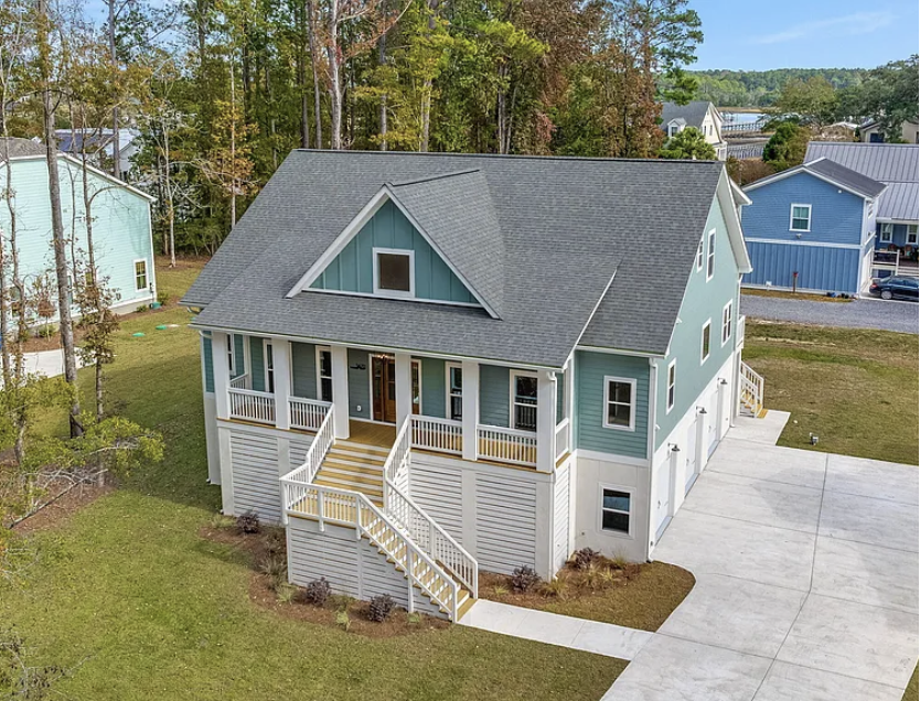 Aerial view of home with gabled roof and garage doors