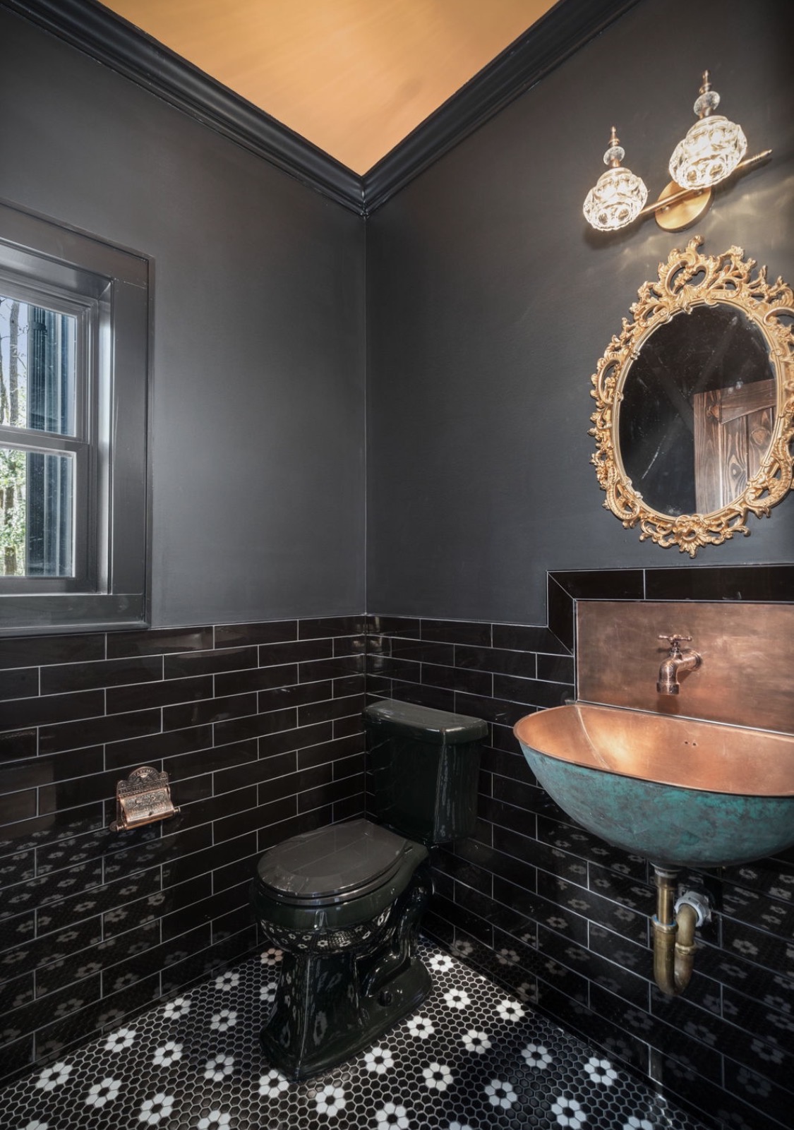 Powder room with copper basin and ornate gold mirror