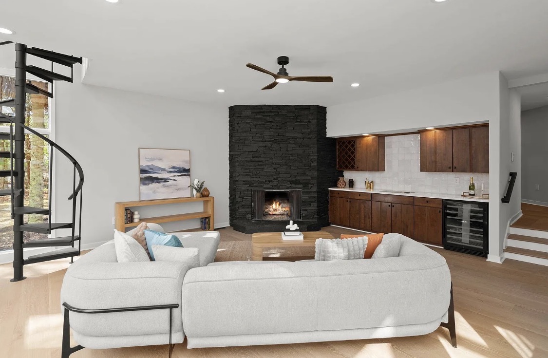 Living area with black stone fireplace and wet bar