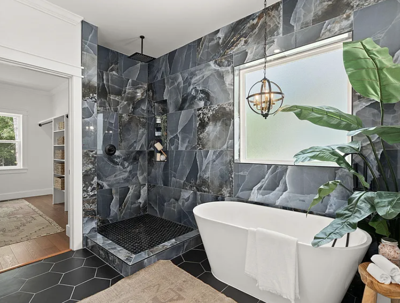 Primary bath walk-in shower with dark marble tile and freestanding tub