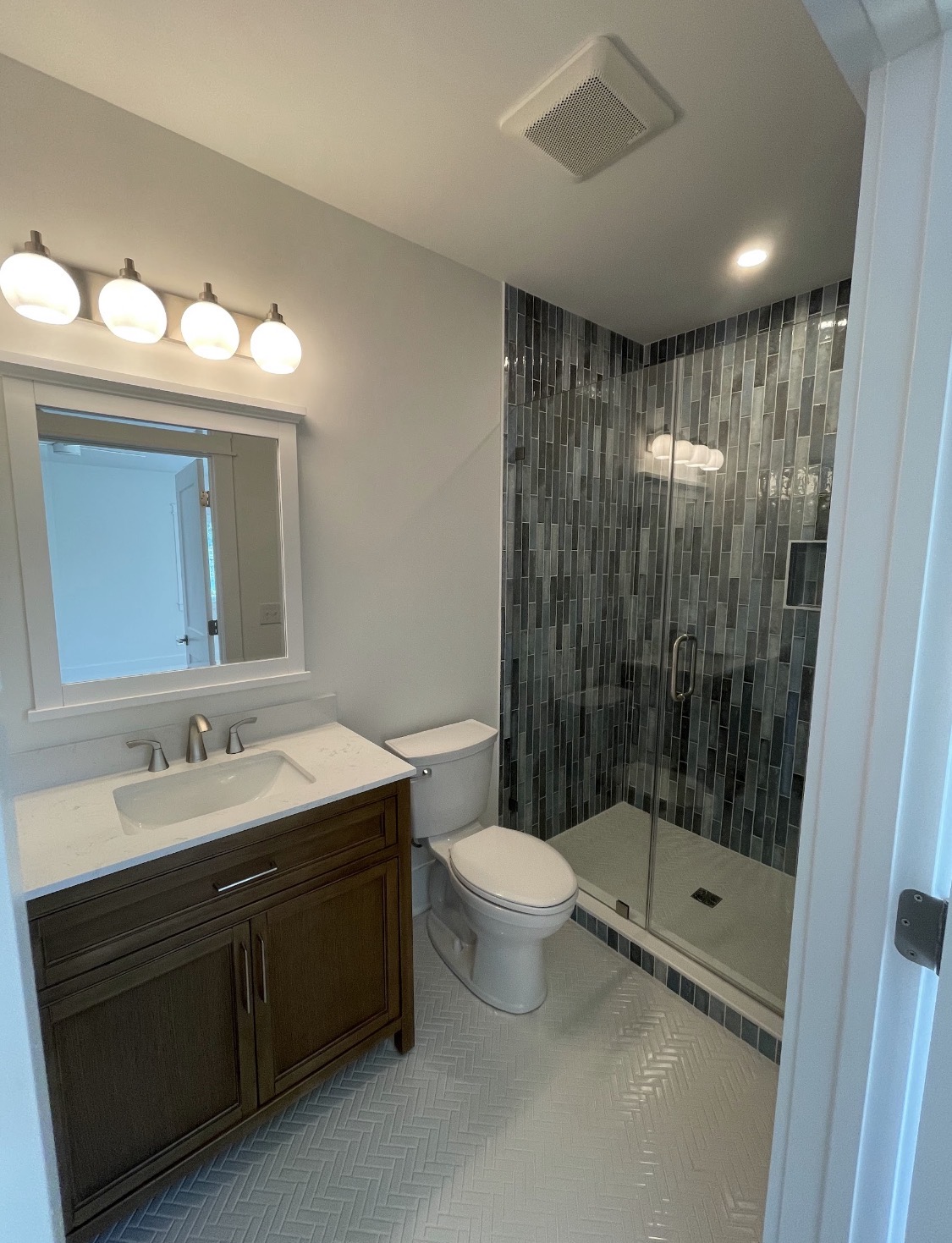 Bathroom with dark wood vanity and glass shower enclosure